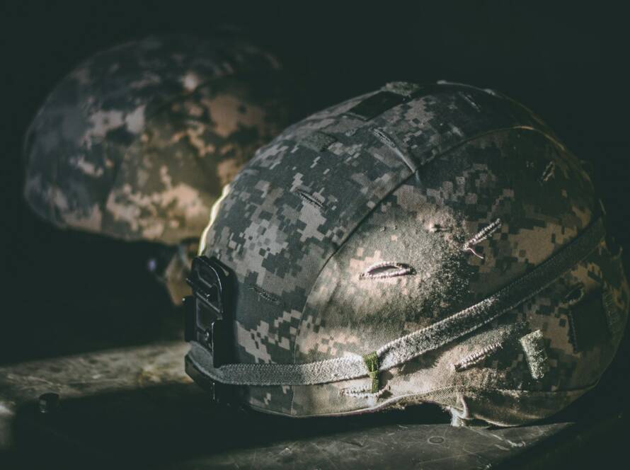 gray and brown camouflage nutshell helmet on table